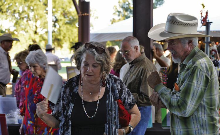 Delaine Shroyer (left) and husband Ronny Shroyer look for the perfect silent auction item during Saturday’s Boots and Blazers Ball hosted by the Lampasas Association for the Arts. ERICK MITCHELL | DISPATCH RECORD