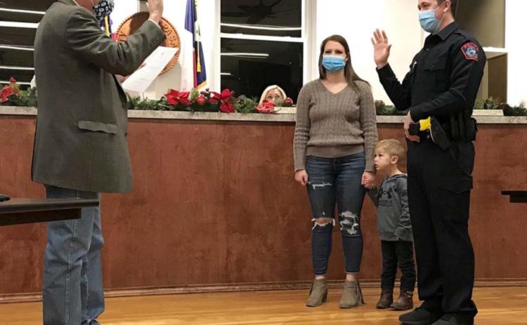 During a Lampasas City Council meeting last week, Municipal Judge Robert Gradel swears in Dylan Boivin -- accompanied by his wife and son -- as a Lampasas Police Department officer. Boivin graduated from Lampasas High School and previously served as a deputy at the Lampasas County Sheriff’s Office. MADELEINE MILLER | DISPATCH RECORD