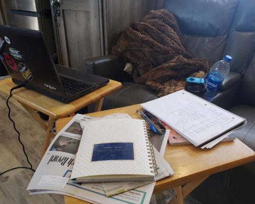 This less-than-illustrious work space of an at-home journalist and writer is made up of a laptop, TV trays, notebooks and an all-purpose chair. PHOTO BY ALEXANDRIA RANDOLPH