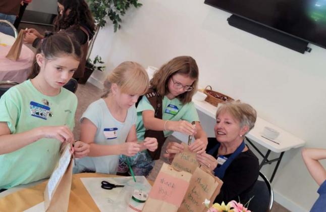 Assembling police survival kits before their delivery to the local department are Girl Scouts Emma-Lee Bull, Evelyn Peterson and Jenna Paige Linney, with adult helper Joyce Taylor. COURTESY PHOTO