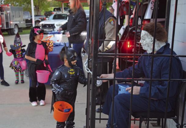 A young Batman receives candy from Michael Myers, dressed as an inmate of the Lampasas County Sheriff’s Office. The Kempner Volunteer Fire Department, Kempner Police Department and Hamilton EMS were all present for Kempner’s Halloween night event. ERICK MITCHELL| DISPATCH RECORD