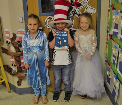 Kindergarten students, left to right, Taylor Maudlin as Elsa, Layne Parker as Cat in the Hat and Harper Keefe as Cinderella pose as their favorite book characters. ERICK MITCHELL | DISPATCH RECORD