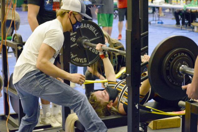 Alyssa Ayers bench presses, while her brother Jason Ayers spots her. 