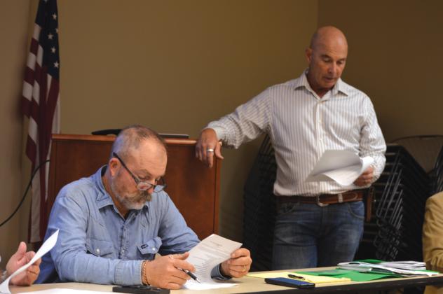 At left, Saratoga UWCD Board President Paul Cline reviews his notes as Director Stan Wilson discusses a change to the district’s fees for non-exempt wells. ERICK MITCHELL | DISPATCH RECORD