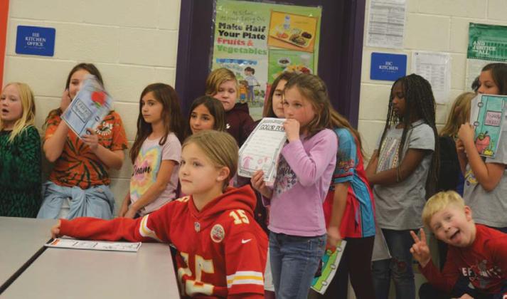 Taylor Creek fourth-grade students watch as classmates deliver their poetry creations. erick mitchell | dispatch record