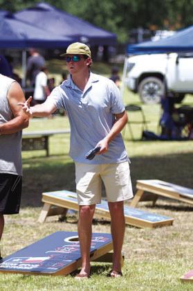 HUNTER KING | DISPATCH RECORD Nate Borchardt tosses a beanbag during the cornhole tournament.