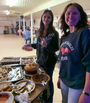 Ashlynn Adams, at left, and Lyla Skiles serve food at a veterans dinner offered in partnership with Community Kitchen. courtesy photo