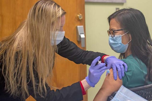 Juana Groat, director of nursing at AdventHealth Rollins Brook, administers a Pfizer COVID-19 vaccine to Michelle Lee. COURTESY PHOTO