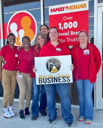 Employees, from left to right, Takira Green, Krystal Waters, Chris Wade, Connie C., Ashly Gilmore and Heather LaRue display the placard naming their store a Night Sky Friendly Business. courtesy photo
