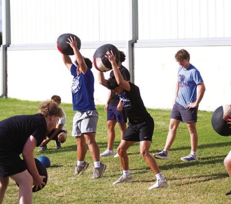 Young Badgers work with medicine balls during SWAT workouts on Wednesday. HUNTER KING | DISPATCH RECORD