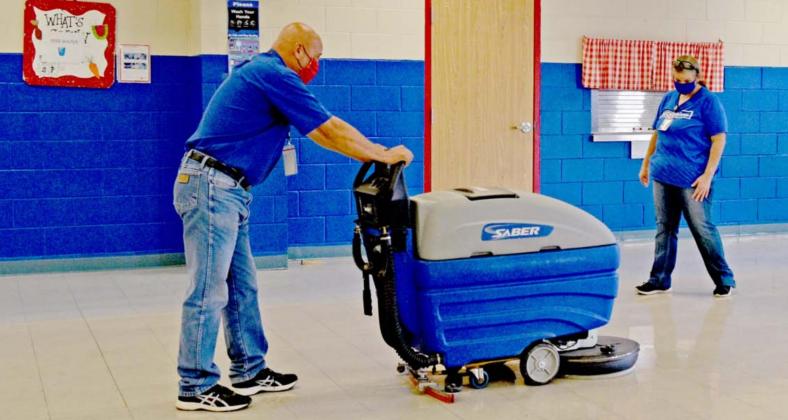 Richard Maceyra Sr., Lampasas Independent School District custodial supervisor, and Sylvania West, morning shift custodian at Hanna Springs Elementary School, clean the school’s cafeteria floor at day’s end. MADELEINE MILLER | DISPATCH RECORD