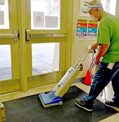 Raymond Valles, a floor technician at Hanna Springs Elementary School, vacuums the school’s vestibule floor shortly before the end of the school day. MADELEINE MILLER | DISPATCH RECORD