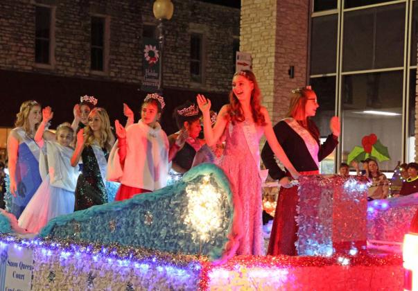 The 2023 Snow Queen Court waves to the crowd during the Carol of Lights Holidazzle Parade on Saturday. The Snow Queen Court was selected earlier that day during a pageant at the courthouse bandstand. JOYCESARAH MCCABE | DISPATCH RECORD