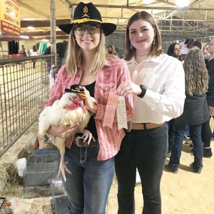 Emma Jones, left, holds a broiler she raised and presented at the Lampasas County Youth Livestock Show. FFA awarded Jones $1,000 for her project of raising nearly 30 chickens in her garage. COURTESY PHOTO