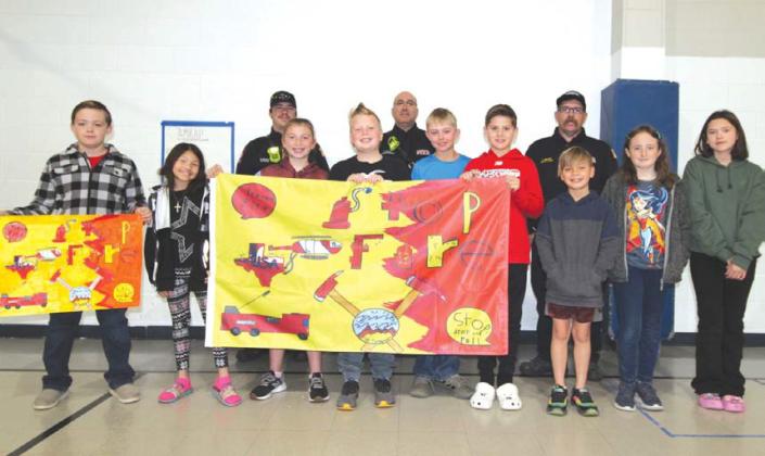 Fifth-grade flag design winners from Hanna Springs Elementary School are, front row from left, Ryder Hill, Kaydence Staab, James Hesselbacher, Holley Wakeman, Austin Flick, Hadley Khul-Gosnell, Cutter Sellers, Megan Cross and Zoee Booth. Their teacher is Tyler Coonrod. On back row are Lampasas Fire Marshal JP Harris, Capt. Colton Baker and Deputy Chief Corey Greiner. JOYCESARAH MCCABE | DISPATCH RECORD