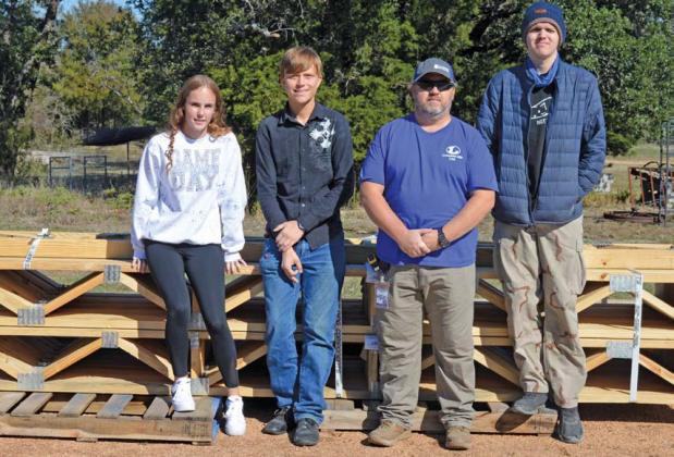 Standing next to materials earmarked for the tiny home project are, from left to right, Amber Beuermann, Thomas Cox, CTE teacher Richard Silva-Brown and Ethan Sanders. The students are all involved in Lampasas High School’s construction program. Erick mitchell | dispatch record