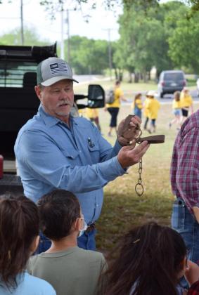 Patrick Flanigan, a wildlife damage management specialist, shows students how a traditional leg trap is set when the USDA Wildlife Service is called in to manage a predator population. ALEXANDRIA RANDOLPH | DISPATCH RECORD