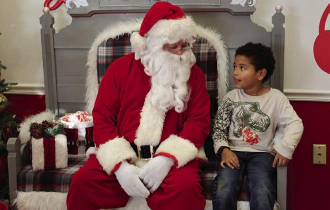 Alex Johnson, 5, has a conversation with Santa about what he sure would like to have under his tree Christmas morning. Santa was set up at the Ajinomoto Foods lobby to visit with area residents. JOYCESARAH MCCABE | DISPATCH RECORD