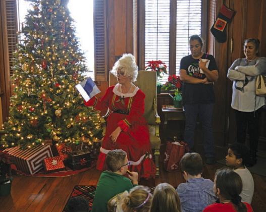 Mrs. Claus reads stories to children during her visit to Lampasas on Saturday at the Manual Hardware building. ERICK MITCHELL | DISPATCH RECORD