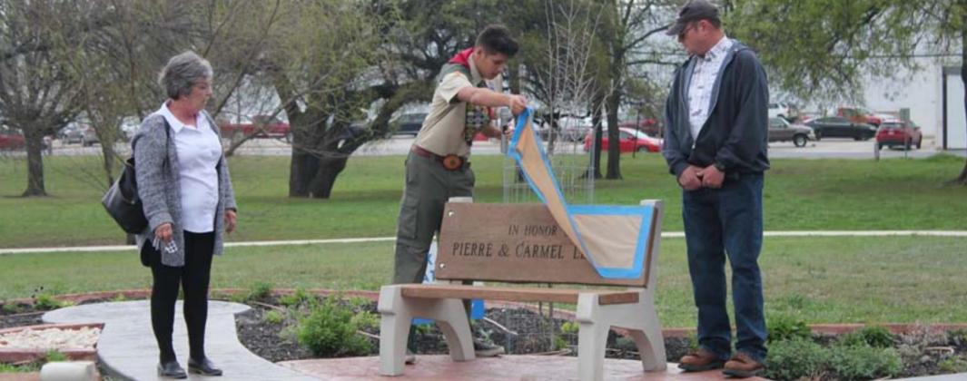 During the dedication of his Eagle Scout project, John T. Saucedo reveals the engraving on a bench he dedicated to Carmel and Pierre LeBlanc – left and right. CHRIS YBARRA | DISPATCH RECORD