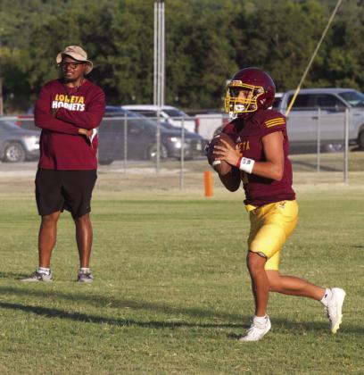 Lometa’s Jose Carbajal rolls out of the pocket as head coach Terrence Wadley observes during Thursday’s home scrimmage against Menard and May. ERICK MITCHELL | DISPATCH RECORD