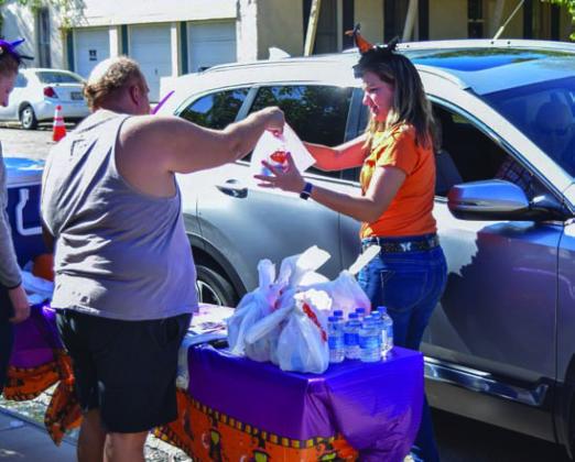 Volunteers help distribute barbecue sandwiches curbside at a previous BBQ for Books event. FILE PHOTO