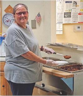 Theresa Weichert serves barbecue beef to feed those who gather for a meal and socialization at the Lampasas Senior Center. Joycesarah McCabe | Dispatch Record