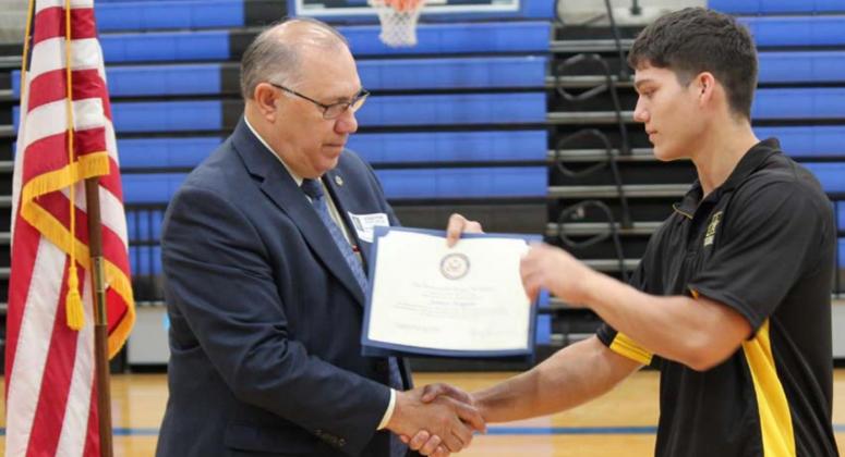 Donald Nicholas hands Lampasas High School senior James Hogan a certificate of congratulations on behalf of Congressman Roger Williams of the 25th District of Texas. CHRIS YBARRA | DISPATCH RECORD