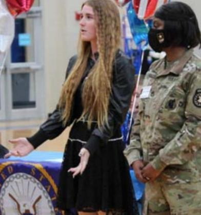 Senior Raelean Sutton, standing next to U.S. Army recruiter Staff Sgt. Redar, speaks to the audience about her enlistment. CHRIS YBARRA | DISPATCH RECORD