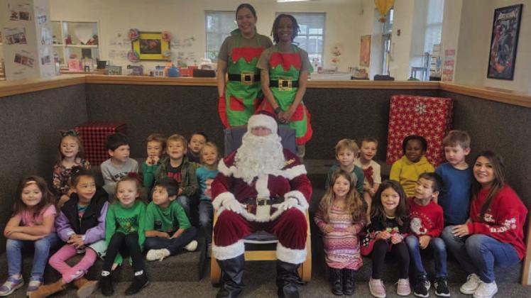 Mrs. Mickan’s kindergarten class poses for a photo with Santa Claus and two of his elves. COURTESY PHOTO