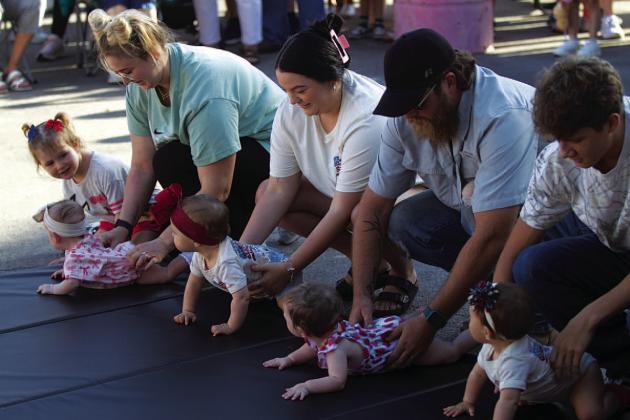 Parents help line up their baby racers before Diaper Derby action gets underway outside the Lampasas County Courthouse on Friday morning. HUNTER KING | DISPATCH RECORD