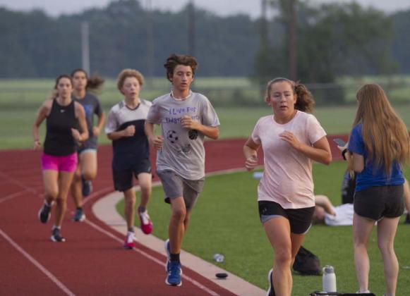 Tyler Ecker and Abby Valdez race around the track at Lampasas High School during cross country practice. HUNTER KING | DISPATCH RECORD