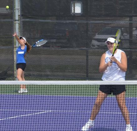 Abby Valdez serves while Kailr Clements stands ready near the net on Monday, the first of a several-day district tennis tournament in Stephenville. KENNETH PEISER | COURTESY PHOTO