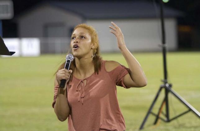 Juliana Dwamena takes a knee and speaks to God during Fields of Faith. HUNTER KING | DISPATCH RECORD