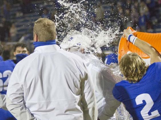 Quarterback Ace Whitehead (2) dumps a Gatorade cooler on head coach Troy Rogers (back-center of photo. Also pictured is Offensive Coordinator Heath Naragon (facing away from camera). JEFF LOWE | DISPATCH RECORD