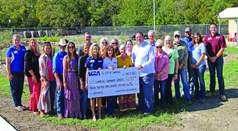 Lampasas Community Garden Director Janet Crozier stands in center, between Mayor Herb Pearce and LCRA representatives Carol Freeman and Meg Voelter to receive a grant for projects and improvement for the garden.