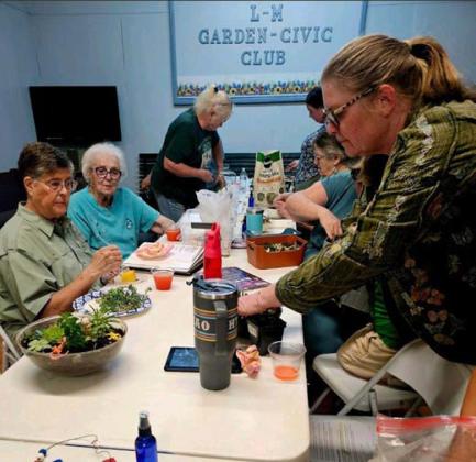 Cat Cotman at right gives instructions on how to make a succulent fairy garden. COURTESY PHOTO