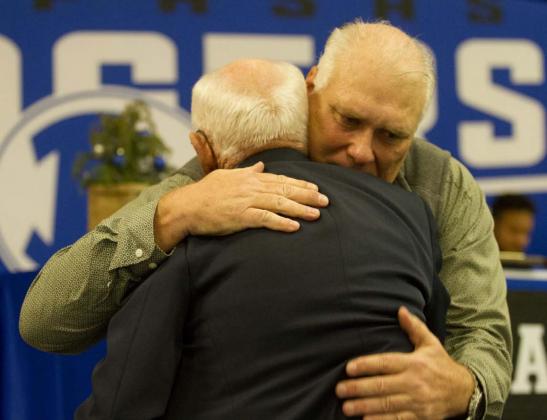 Curtis Thrift, a former Lampasas Badger standout hugs his former coach Ken Wiginton after speaking on him during his Hall of Fame induction at the 2021 Badger Football Banquet last Monday. HUNTER KING | DISPATCH RECORD