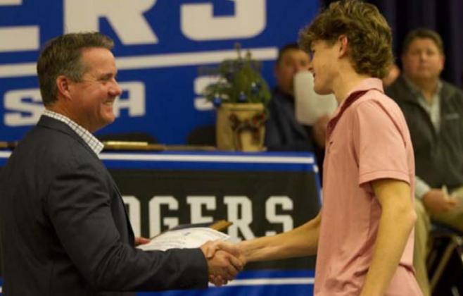 Nate Borchardt shakes hands with Rogers as he receives the Most Eligible Receiver Award. HUNTER KING | DISPATCH RECORD