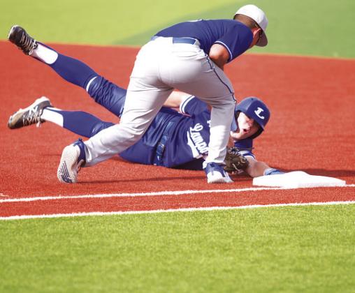 HUNTER KING | DISPATCH RECORD Rawlin Smith dives back into first base after a pickoff attempt during last week’s game.