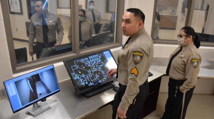 Lampasas County Sheriff’s Office Sgt. John Reza, left, monitors one of the jail’s security cameras as Detention Officer Elaine Tobar looks on. MONIQUE BRAND | DISPATCH RECORD