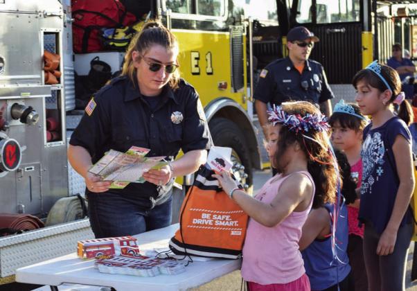 After having to cancel the local observation of National Night Out last year, law enforcement agencies and officials will stage the community engagement event again this year. Booths with giveaways will be set up, as is pictured here, and food and activities will be offered. FILE PHOTO
