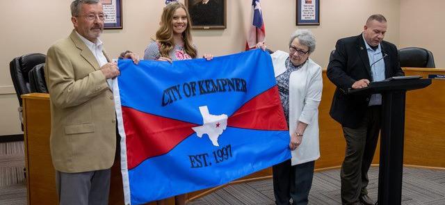 CHRIS MILES | DISPATCH RECORDGene Isenhour, Hayleigh Talasek and former mayor Carolyn Crane hold the new Kempner City Flag as Mayor Wilkerson reads the decree establishing the flag.