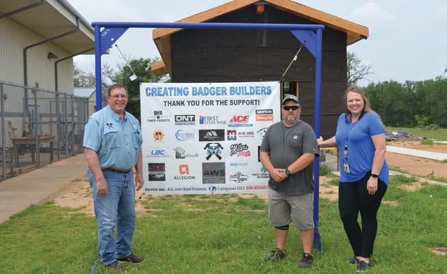 Creating Badger Builders President Herb Pearce, at left, stands with high school construction teacher Richard Silva-Brown and CTE Director Liz Haviland by a sign recognizing the project sponsors. erick mitchell | dispatch record