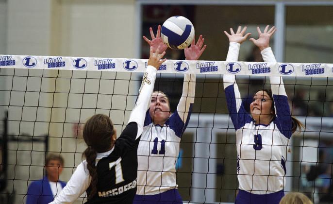 HUNTER KING | DISPATCH RECORD Ava Dowdy, left, and Lilee Hamill jump up for a block. Hamill finished the first game of the season with three blocks.