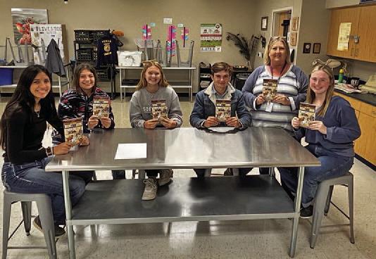 Judy Hail, standing at right, and some of her students display the “Hank the Cowdog” books given to the LISD agriscience program. COURTESY PHOTO