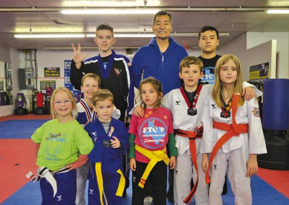 Master Chung Lee, center, stands alongside students from his Lampasas taekwondo studio on Monday. ERICK MITCHELL | DISPATCH RECORD
