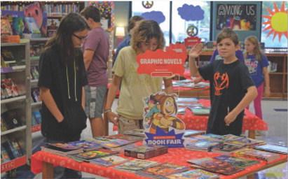 Seventh-grade students in Jennifer Baker’s class scan a display for books that may interest them at Lampasas Middle School’s Scholastic Book Fair. erick mitchell | dispatch record
