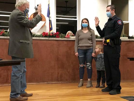 During a Lampasas City Council meeting last week, Municipal Judge Robert Gradel swears in Dylan Boivin -- accompanied by his wife and son -- as a Lampasas Police Department officer. Boivin graduated from Lampasas High School and previously served as a deputy at the Lampasas County Sheriff’s Office. MADELEINE MILLER | DISPATCH RECORD
