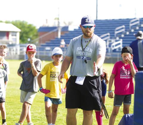 Assistant coach Chance Evans teaches a pass rush drill to campers on Wednesday. HUNTER KING | DISPATCH RECORD